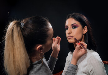 Professional artist fixing fashion model make up