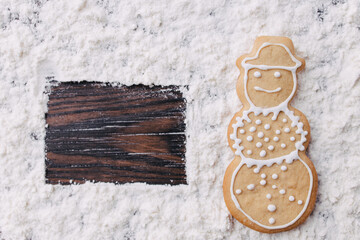 Wall Mural - Christmas and New Year traditional attribute, festive sweets for kids, celebration mood. Homemade gingerbread snowman cookie on wooden table