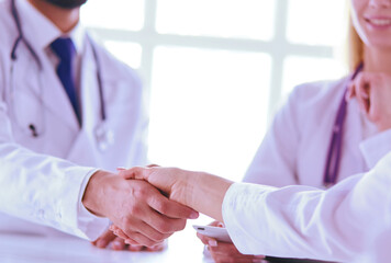 Wall Mural - Doctor shaking hands with a male patient in the office