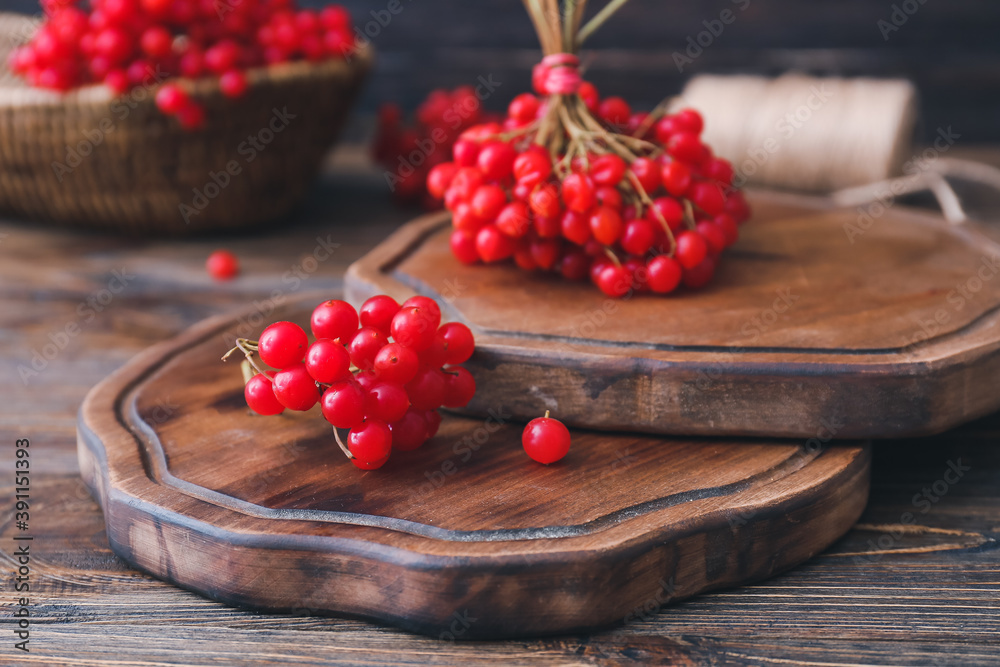 Boards with fresh viburnum berries on table