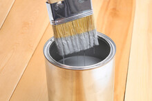 Brush With Can Paint In Hand. A Man Paints Wooden Boards In Gray Paint Brush.