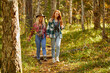 © Roman - two friendly women hiking together, go forward in the forest. young and beautiful travellers in the nature