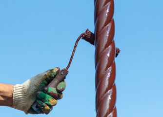 Wall Mural - A worker paints a metal pipe