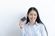 © Puwasit Inyavileart - White Asian woman holding a credit card and smiling bright