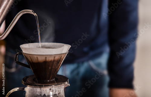 Person Dripping Coffee at Home in the Morning. Zen and Cozy Living. Pouring Hot Water from Kettle into a Dripper. Closeup shot