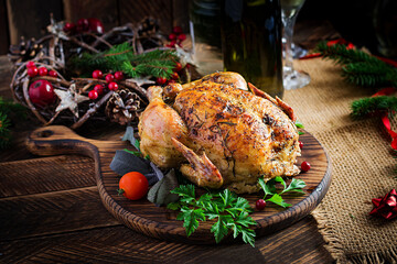 Baked turkey or chicken. The Christmas table is served with a turkey, decorated with bright tinsel. Fried chicken, table setting. Christmas dinner.