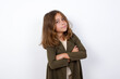 © Jihan - Waist up shot of  self confident Beautiful little girl standing against white background, has broad smile, crosses arms, happy to meet with colleagues.