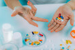 © Microgen - Prescribed medication non-adherence. Female patient counting pills.