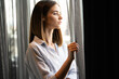© NDABCREATIVITY - Portrait of a beautiful girl standing at the window