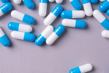 white and blue pills on a gray background. medical background