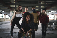 Group Of Teenagers Gang Standing Indoors In Abandoned Building, Bullying Concept.