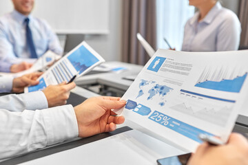 Canvas Print - people and corporate concept - close up of happy business team with papers meeting at office