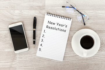 Wall Mural - New Year's Resolutions text on note pad with smart phone and cup of coffee