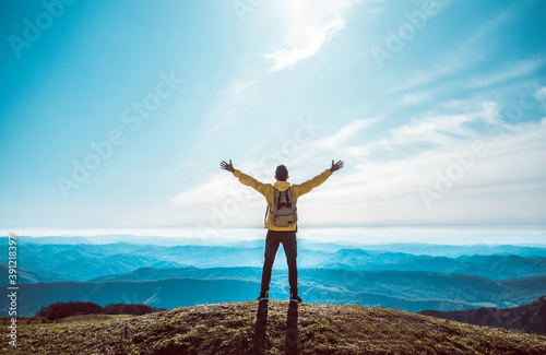 Cuadros en Lienzo Successful man with arms up on the top of the mountain - Hiker on the cliff raising hands to the sky