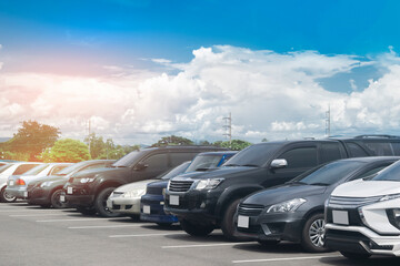 Wall Mural - Cars parking in asphalt parking lot in a row with blue sky background. Outdoor parking lot with fresh ozone, green nature environment of transportation