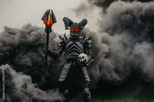 Fotografía Mutant warrior stands with glowing eyes against a background of black smoke