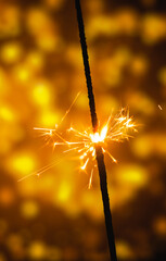 Wall Mural - Lighted sparkler on a beautiful festive background vertical photo