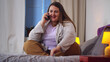© TommyStockProject - Portrait of overweight happy woman talking with friend on mobile phone sitting on bed