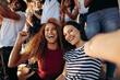 © Jacob Lund - Excited female spectators making a selfie at stadium