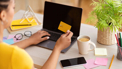 Aufkleber - Black woman using laptop and credit card at home