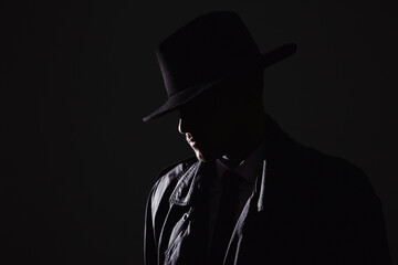 Wall Mural - Old fashioned detective in hat on dark background