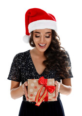 Beautiful woman in Santa hat with Christmas gift on white background