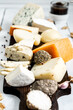 Various types of cheese. On a white wooden background. Blue cheeses with spices. Around honey and walnuts. Home cheese dairy