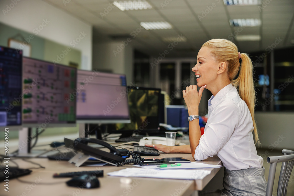 Smiling successful hardworking businesswoman in suit sitting in control ...