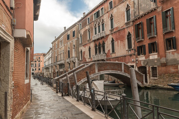 Alley view with historical buildings in Venice, Italy.