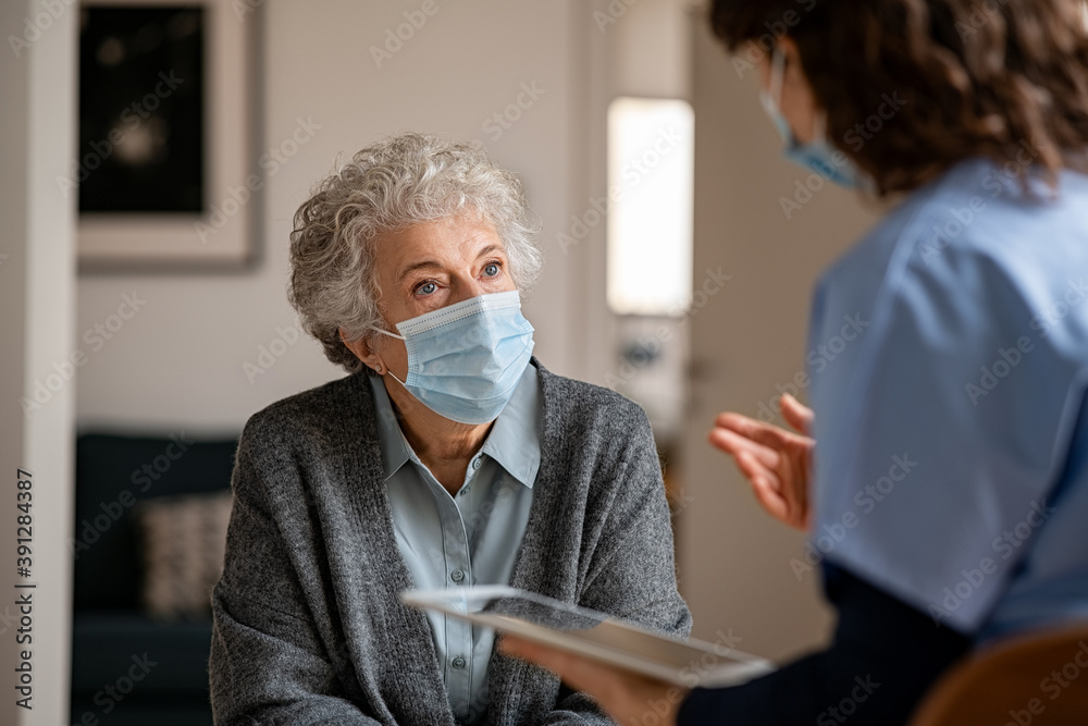 Doctor home visit a senior woman during the covid-19 pandemic - obrazy, fototapety, plakaty 