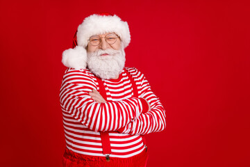 Profile photo of retired old man crossed arms self-assured empty space wait last december days wear santa costume suspenders spectacles striped shirt headwear isolated red color background