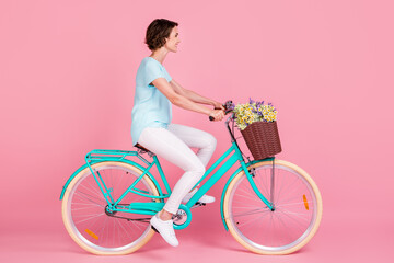 Wall Mural - Profile full length photo of cute lovely woman riding vintage bicycle wear blue t-shirt white trousers shoes isolated pink background