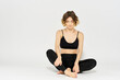 © SHOTPRIME STUDIO - Woman in leggings meditate in a light room with her legs crossed yoga asana