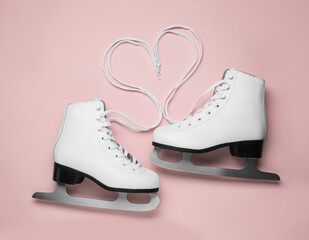 Wall Mural - pair of white ice skates on pink background, top view