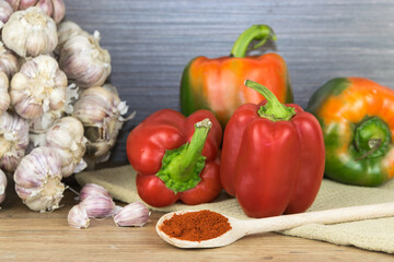 Wall Mural - Natural, organic red pepper on wooden background  and a bunch of garlic