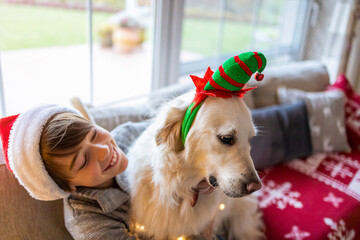 Canvas Print - Boy and his dog enjoying Christmas together at home 
