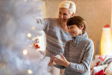 Wall Mural - Mother and son decorating Christmas tree 
