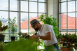 © ake - senior retired Caucasian man with smoking pipe doing indoor gardening in home greenhouse planting herb and green vegetable