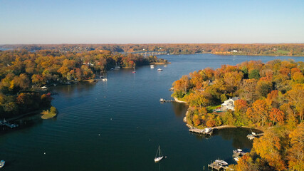 aerial view of colorful sailboat moorings, docks, and bright golden foliage on weems creek, in histo