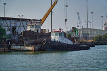 HAIFA, ISRAEL - Aug 29, 2020: Old Boat In Haifa Harbor In Israel With Rust And Cranes In Background Near The Waterfron