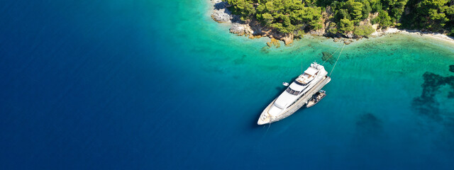 Wall Mural - Aerial drone ultra wide panoramic photo of luxury yacht anchored in tropical exotic island with crystal clear turquoise sea and pine trees