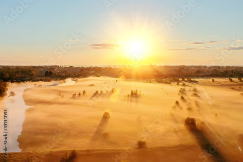Cuadros en Lienzo Autumn fog over the field and shadows from trees and bushes in the countryside next to the river, view of a drone flight from a height