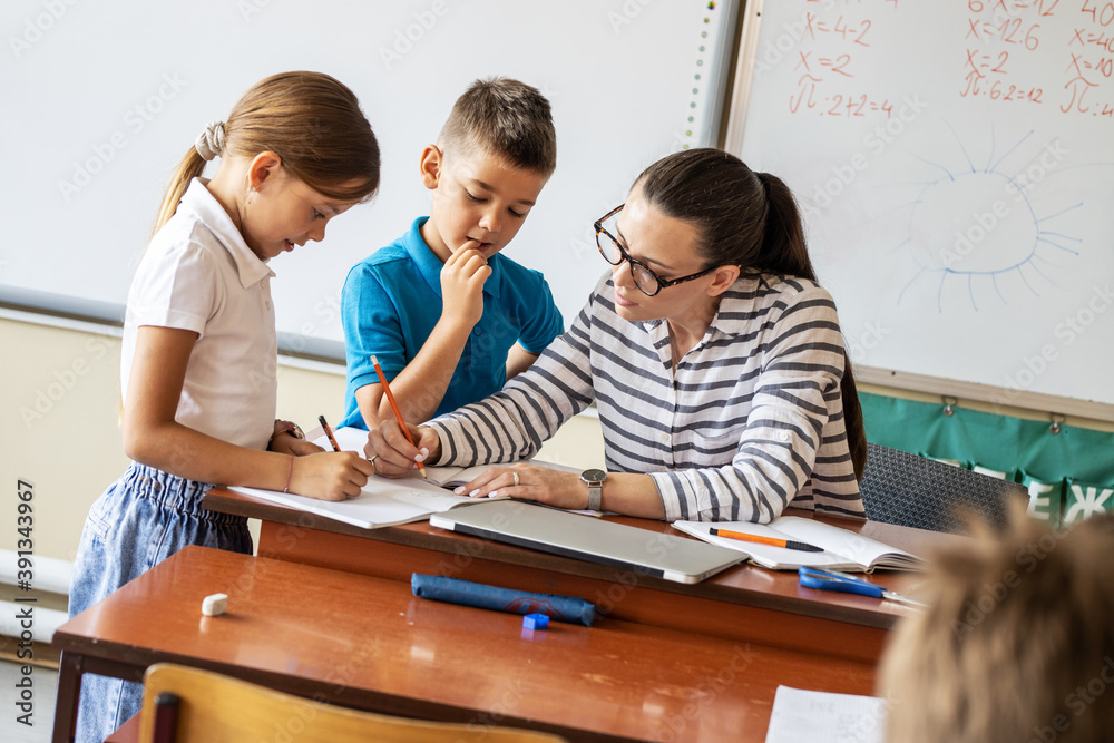 In the classroom's cozy setting, the caring female teacher diligently ...