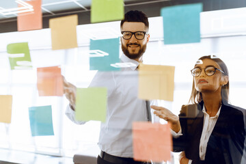 Business colleagues brainstorm with sticky notes at work in office