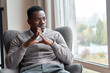 © insta_photos - Confident serious focused stylish rich african black man sitting in chair at home looking away through window dreaming thinking of success, leadership, business vision, planning future in luxury life.