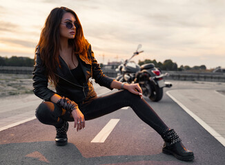 Sensual motorcycle girl posing on the track