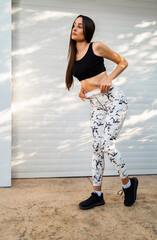 Wall Mural - Amazing fit girl posing in attractive yoga pants, accent on abs