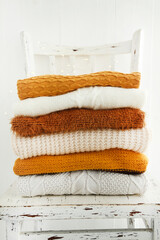 Wall Mural - Folded knitted sweaters on white wooden chair