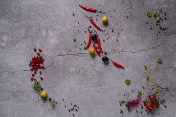 Mortar and Pestle , wooden spoon and various fresh green seasoning and spices on gray stone background, top view frame. Healthy eating and cooking concept.