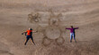 © Yakov Knyazev/Stocksy - drone selfie of a young couple on the sand laying with a drawn rabbit
